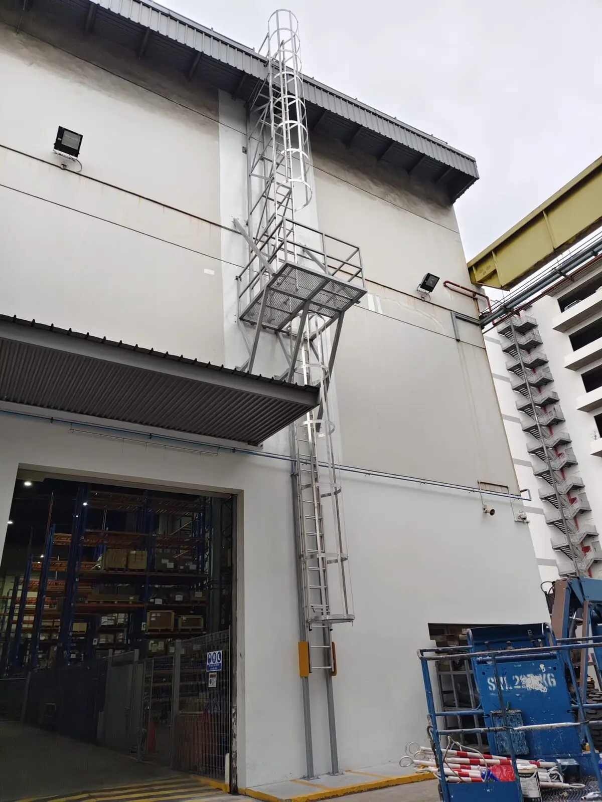 Buroh Street cat ladder running from ground level past warehouse roller-shutter to roof eaves